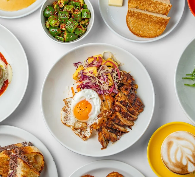 BBQ chicken rice bowl, beef dip, salads and coffee on a table at Barako Bistro, seen from above