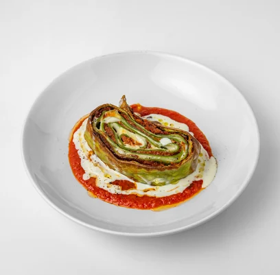 House lasagna verde, rolled green spinach pasta with bolognese, on tomato sauce with white sauce
